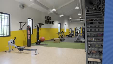 Espacio-De-Fitness-Vacío-Con-Equipamiento-De-Fitness,-Bolsa-De-Boxeo,-Máquinas-Cardiovasculares,-Entrenamiento-Cruzado