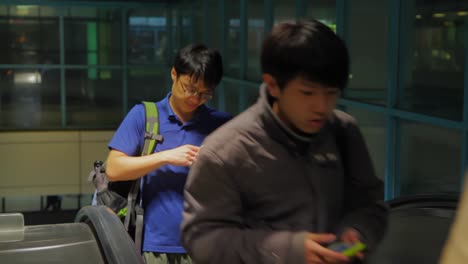 Endless-stream-of-young-adult-Asian-people-coming-up-on-escalator