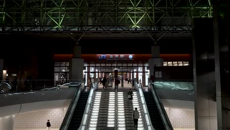 Beautiful-symmetrical-shot-of-the-escalators-at-the-Takayama-train-station-in-Japan,-where-many-people-pass-by-to-board-the-train