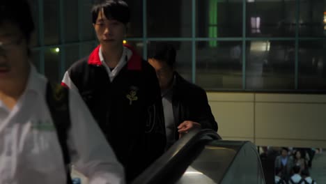 Variety-of-male-and-femaly-young-adult-Asians-walking-up-escalator-in-metro-station