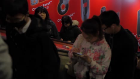 Watching-stream-of-people-ascending-while-descending-escalator-ending-in-close-up-face