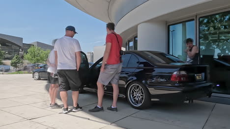 La-Gente-Estaba-Parada-Alrededor-De-Un-Automóvil-BMW-M5-E39-Negro-Hablando-En-El-Museo-De-Munich,-Alemania.