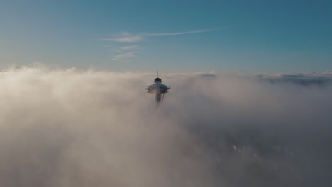 Aerial-orbit-around-iconic-city-building-breaking-the-dense-layer-of-fog