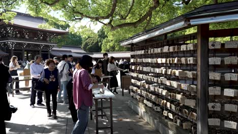 Visitantes-Escribiendo-Deseos-Y-Oraciones-En-Placas-De-Madera-Ema-En-El-Santuario-Meji.