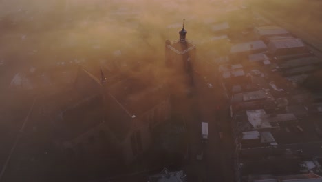 Aerial-drone-view-of-church-foggy-morning,-Workum,-Friesland,-Netherlands