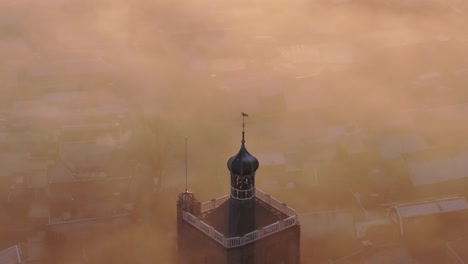 Aerial-drone-view-of-church-foggy-morning,-Workum,-Friesland,-Netherlands