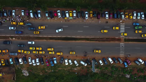 Drone-De-Arriba-Hacia-Abajo-Disparado-Sobre-El-Tráfico-Y-Los-Autos-Estacionados-En-La-Ciudad-De-Yaundé,-Camerún