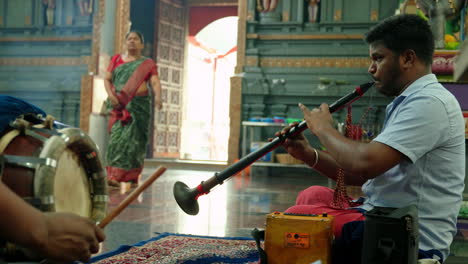 View-of-2-Indian-men-sitting-on-the-floor-playing-ritual-music-inside-Hindu-temple