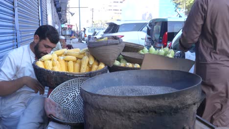 Nahaufnahme-Eines-Ladenbesitzers,-Der-Bei-Sonnenuntergang-An-Einem-Stand-Am-Straßenrand-In-Der-Saddar-Bazar-Street-In-Karatschi,-Pakistan,-Geröstete-Körner-Verkauft