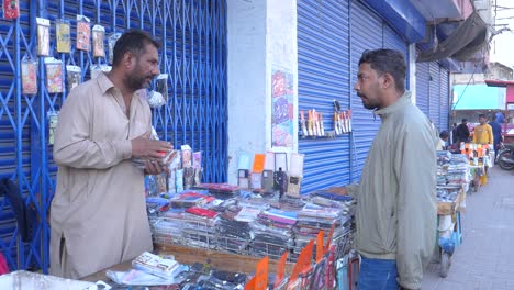 Filmaufnahme-Eines-Ladenbesitzers,-Der-An-Einem-Wintermorgen-In-Der-Saddar-Basar-Straße-In-Karatschi-Mobiltelefonhüllen-In-Jacke-An-Seinen-Kunden-Verkauft