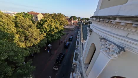 FPV-Drohnenflug-Auf-Der-Straße-In-Der-Kolonialzone-Entlang-Der-Kathedrale-Bei-Sonnenuntergang,-Dominikanische-Republik