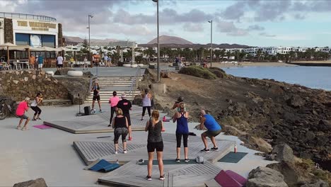 Gente-Haciendo-Ejercicio-En-Una-Clase-Al-Aire-Libre-En-El-Paseo-Marítimo