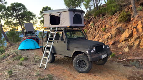 Dos-Fantásticos-Coches-Jeep-4x4-Con-Tiendas-De-Campaña-En-La-Azotea-Con-Vistas-A-La-Naturaleza-Y-A-La-Montaña-Del-Bosque-Verde,-Divertido-Viaje-De-Aventuras-Al-Aire-Libre-En-Vehículos-Todo-Terreno-En-Marbella-Málaga-España,-Toma-De-4k