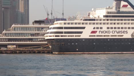 Cinematic-sideview-shot-of-a-luxury-giant-cruise-ship-at-a-harbor-during-day-in-Tsim-Sha-Tsui-in-Hong-Kong