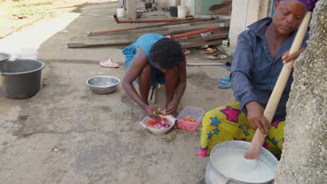 Ghanaian-women-preparing-food,-making-banku-and-cutting-vegetables,-typical-Ghanaian-dish