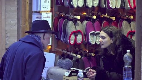 an-elderly-gentleman-talks-to-a-young-female-sales-assistant-at-the-Christmas-market-in-Klausen,-Chiusa,-South-Tyrol,-Italy