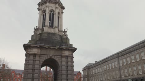 Toma-Cinematográfica-Del-Campanile-Dentro-Del-Trinity-College-Con-Algunos-Estudiantes-Y-Sus-Padres-Durante-Un-Día-Nublado-En-Dublín,-Irlanda