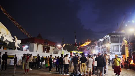 Pan-across-tourists-walking-outside-of-Buddhist-temple-decorated-with-ornate-golden-headdress-and-eyes-on-each-edge