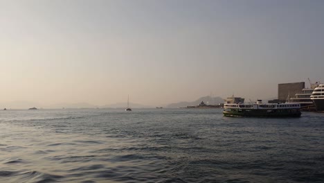 Cinematic-shot-of-a-ship-sailing-on-a-sea-from-Victoria-Harbour-during-evening-in-Hong-Kong