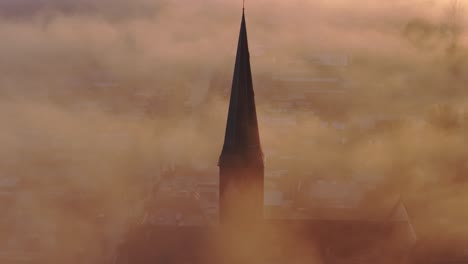 Aerial-drone-view-of-church-foggy-morning,-Workum,-Friesland,-Netherlands