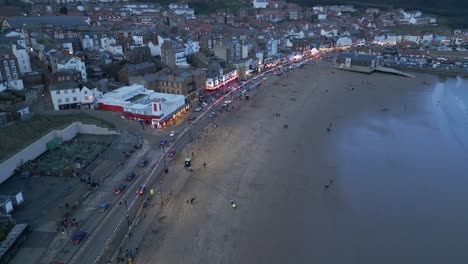 Vista-Aérea-De-Drones-Sobre-Casas-Adosadas-Junto-A-La-Playa-En-Scarborough,-North-Yorkshire,-Inglaterra-Durante-La-Noche