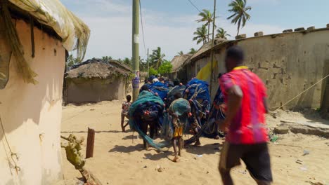 Un-Grupo-De-Africanos-Transportando-Redes-De-Pesca-En-Una-Aldea-De-Ghana.