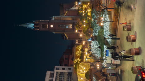 People-Walking-by-Myeongdong-Cathedral-at-Night-in-Seoul,-South-Korea,-High-Angle-Vertical-Time-Lapse