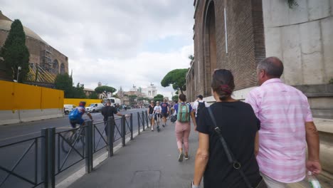 Punto-De-Vista-Inmersivo-En-Roma:-Moverse-Por-Calles-Concurridas-Hasta-Chiesa-Santi-Luca-E-Martina,-Italia,-Europa,-Caminar,-Tembloroso,-4k-|-Chica-Con-Mochila-Apresurándose-Por-La-Concurrida-Acera