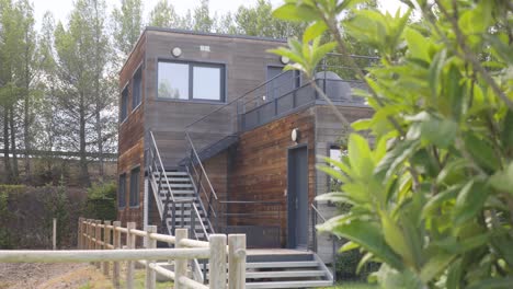 Scenic-wooden-architectural-house-with-cars-driving-along-the-highway-in-the-background