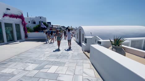 Menschen-Gehen-Auf-Weißem-Bürgersteig-|-Oia,-Santorini,-Griechenland,-Griechische-Insel-Im-Ägäischen-Meer,-Reise,-Touristenurlaub,-Immersiver-Wanderspaziergang-Entlang-Der-Menschenmassen,-Die-In-Klippen-Aus-Weißem-Marmor-Einkaufen,-Und-Stadt,-Europa,-4k