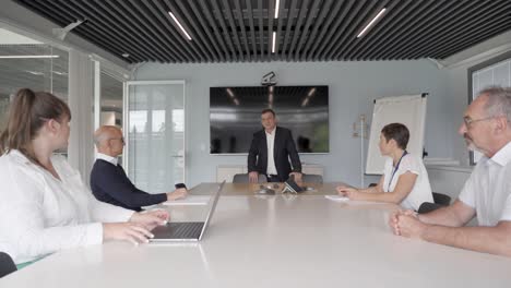 Slow-dolly-shot-inside-a-company-meeting-with-senior-members-attending