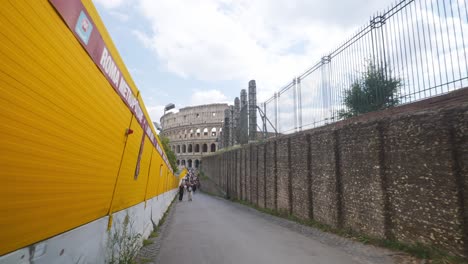 Rome-Immersive-POV:-Moving-In-Busy-Streets-to-Chiesa-Santi-Luca-e-Martina,-Italy,-Europe,-Walking,-Shaky,-4K-|-Women-Walking-Along-Path-In-Front-Of-Colosseum