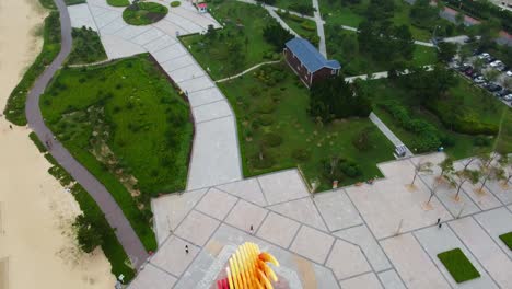 Aerial-view-of-a-lush-green-park-near-a-beach-with-walking-paths-and-residential-buildings-nearby