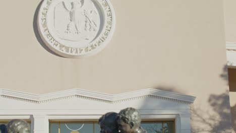 New-Mexico-State-capitol-building-in-Santa-Fe,-New-Mexico-and-children-playing-statue-with-tilt-up-and-pan