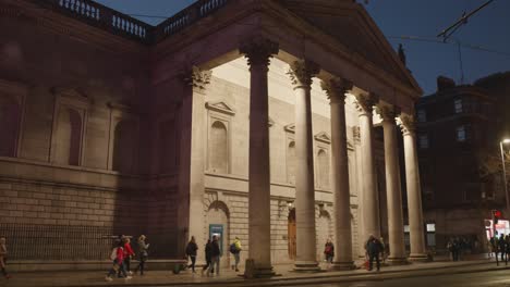 Pedestrians-And-Traffic-Passing-By-In-Front-Of-Irish-Parliament-House-At-Night