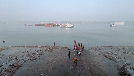 Weitwinkel-Draufsichtaufnahme-Von-Männern,-Die-Morgens-In-Kalkutta,-Indien,-Am-Flussufer-Des-Hooghly-River-Baden