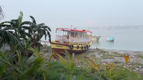 Cinematic-shot-of-a-boat-kept-on-a-river-bank-during-daytime-in-Kolkata,-India