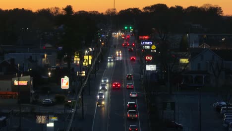 Crepúsculo-Sobre-Una-Concurrida-Calle-Suburbana-Bordeada-De-Brillantes-Carteles-De-Escaparates