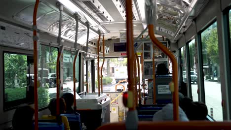 Slow-motion-indoor-shot-of-a-local-bus-with-passengers-in-Kyoto-during-sunny-day-in-Japan