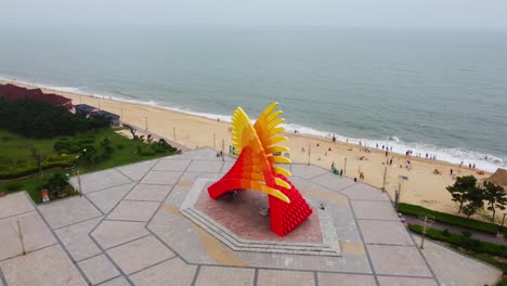 Vista-Aérea-De-La-órbita-Que-Captura-La-Belleza-Del-Monumento-De-Playa-Adornado-Con-Varias-Esculturas-De-Arena.