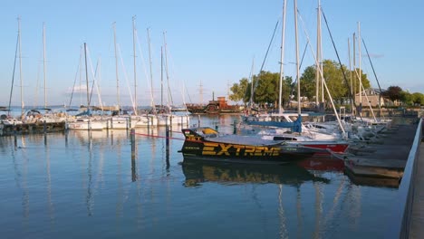 Hungría,-Puerto-Deportivo-De-Balatonfüred-Con-Veleros-Amarrados-Y-Un-Barco-Tradicional-Que-Llega-Al-Fondo