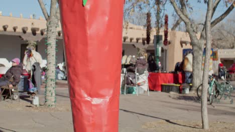 Fröhliches-Chanukka-Schild-Auf-Einem-Kunstwerk-Mit-Roten-Chilischoten-In-Der-Innenstadt-Von-Santa-Fe,-New-Mexico,-Mit-Nach-Oben-Geneigtem-Video