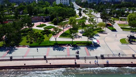 Linker-Panoramablick-Auf-Den-Xingfu-Park-In-Weihai,-China,-Mit-Atemberaubender-Stadtlandschaft-Und-Lebhafter-Menschenmenge-Im-Hintergrund