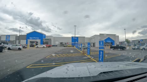 POV-–-Fahrt-über-Den-Parkplatz-Von-Walmart,-Vorbei-An-Dem-Bereich,-Der-Für-Die-Kundenabholung-An-Einem-Bewölkten,-Regnerischen-Tag-Vorgesehen-Ist