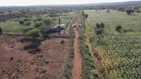 Drilling-borehole-well-in-search-of-fresh-water-supply-on-African-farmland,-aerial