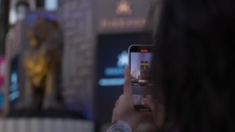 Tourist-Taking-Photo-Of-Gold-Lion-statue-at-Las-Vegas-MGM-Grand-Casino-Hotel-in-Las-Vegas-With-Smartphone