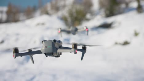 Dji-Air-3-Flotando-Delante-De-Air-2s-Con-Fondo-Bokeh-Blanco-Como-La-Nieve