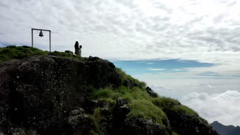 AERIAL-DRONE-CAMERA-Drone-is-moving-forward-where-a-couple-is-walking-on-hills-is