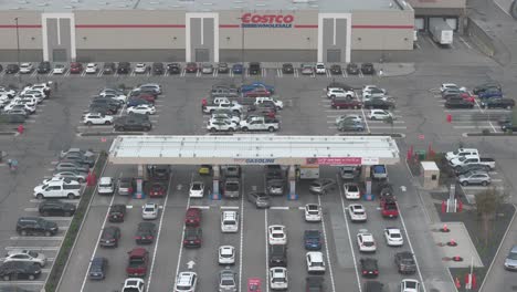 Una-Fila-De-Vehículos-Esperando-Para-Llenar-Gasolina-En-Heritage-Meadows-Costco-En-Calgary,-Alberta,-Vista-Desde-Un-Dron-Aéreo