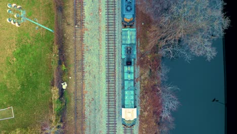 Tren-De-Carga-Rodando-Por-Un-Paisaje,-Panorama-Aéreo